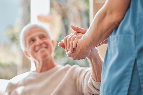 Nurse holding mans hand